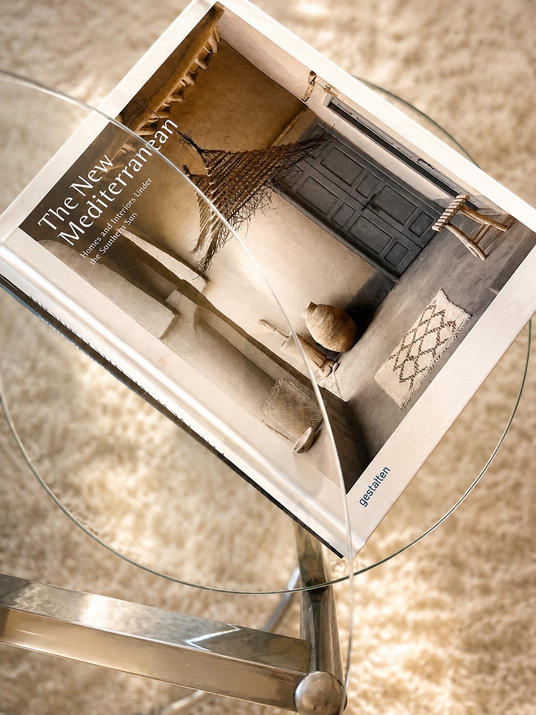 Un livre de décoration posé sur la table basse en verre