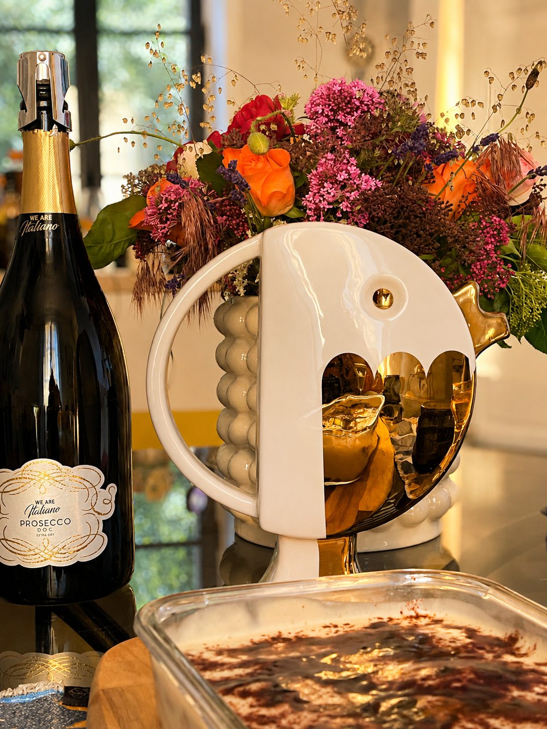 Prosecco, bouquet dans un vase sculptural et dessert maison