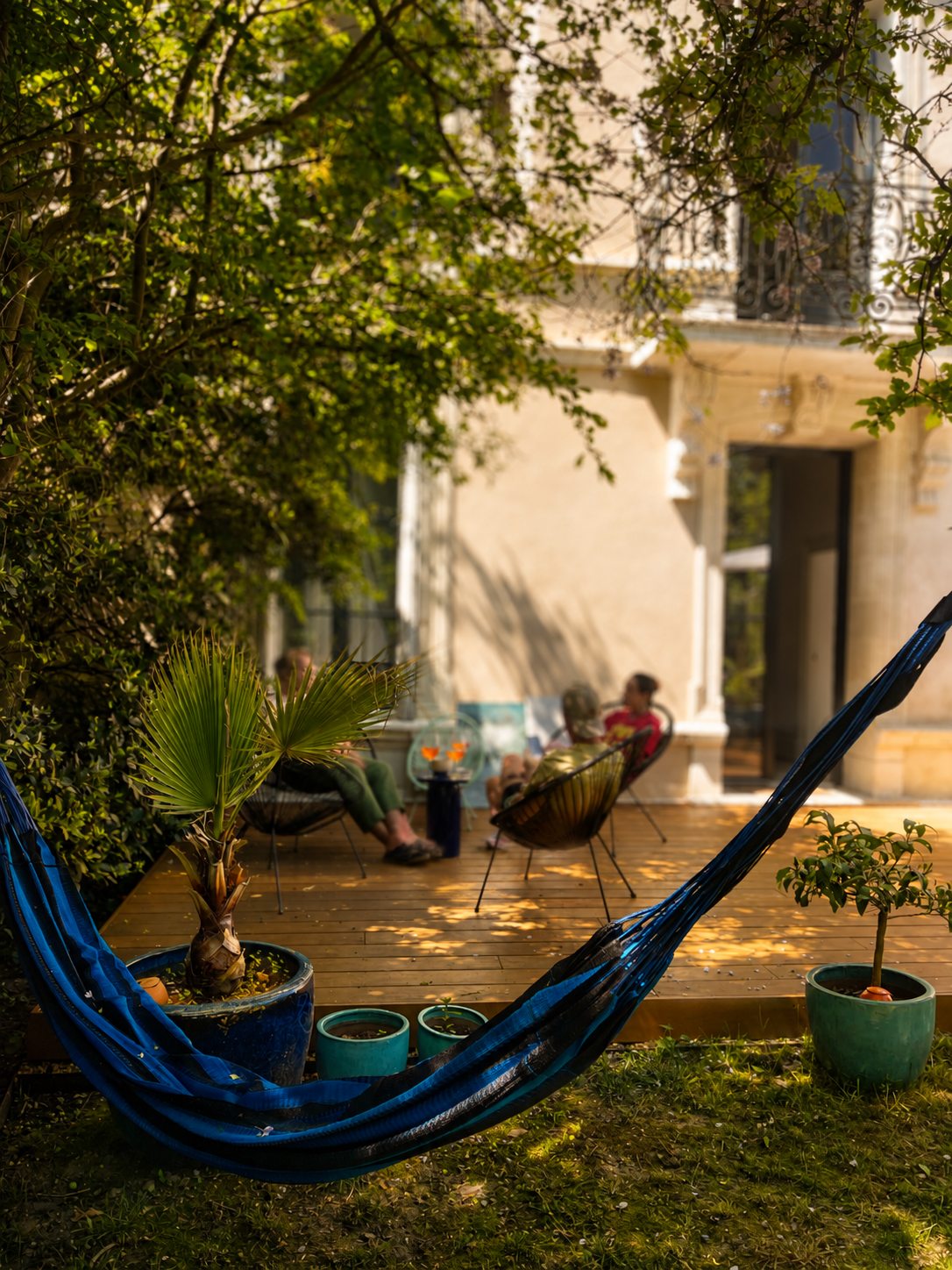 Le jardin de la Villa Folie : hamac tendu entre les arbres centenaires, devant la terrasse en bois