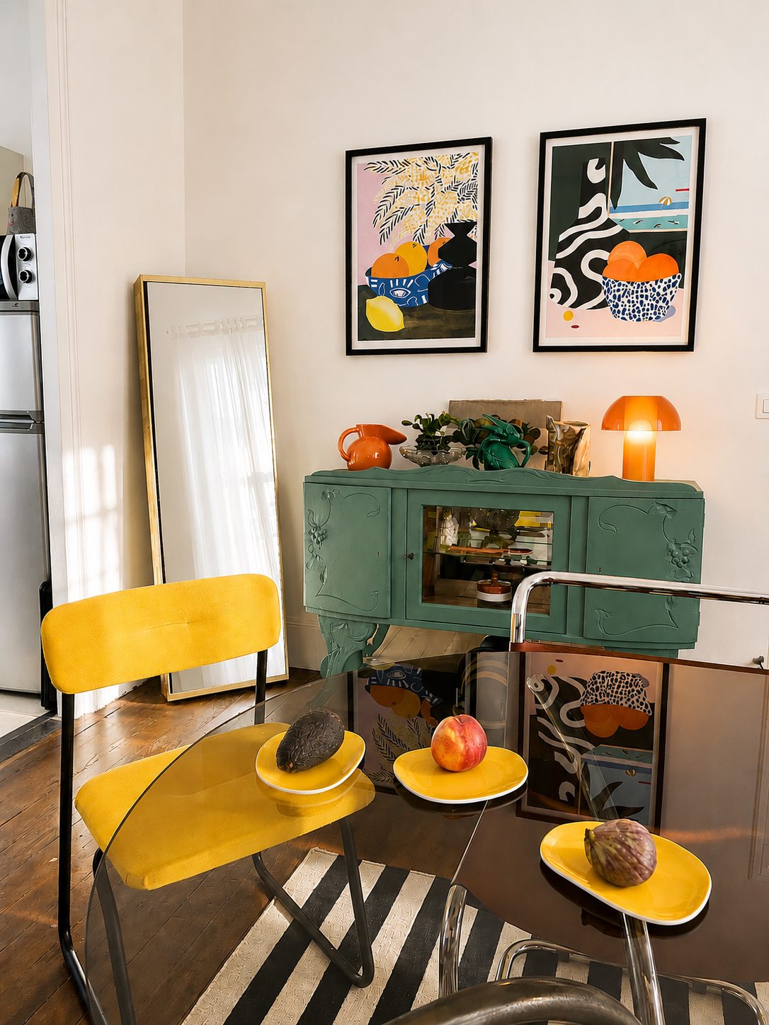 La salle à manger de la Villa Folie : chaises jaunes, buffet vert canard et affiches colorées