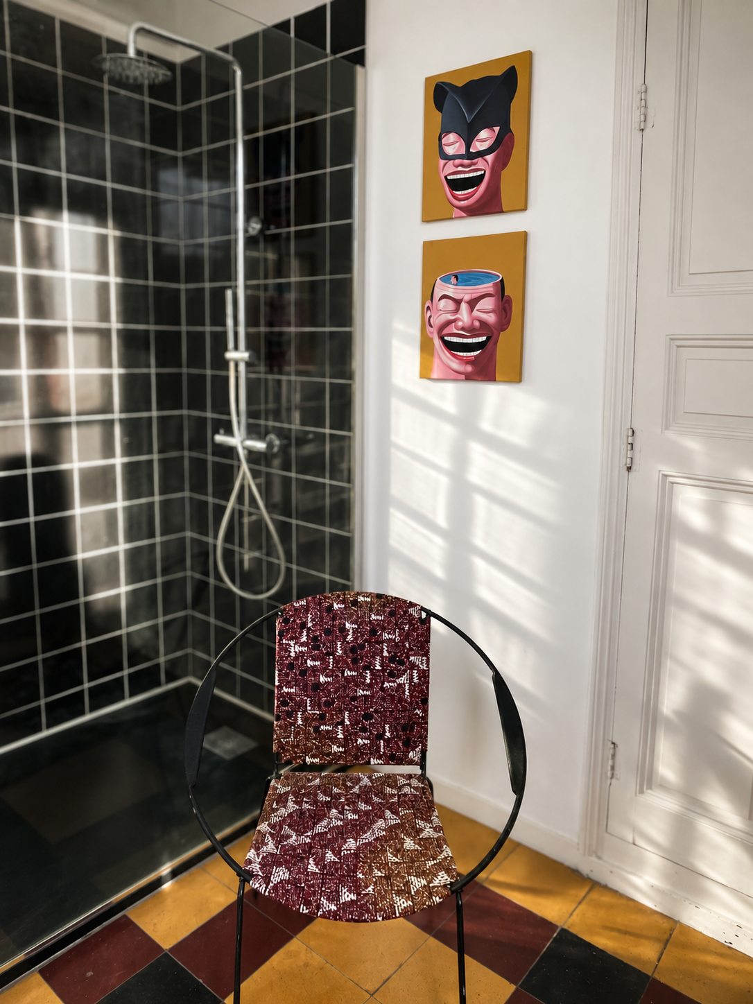 La douche vitrée et le carrelage noir de la salle de bain