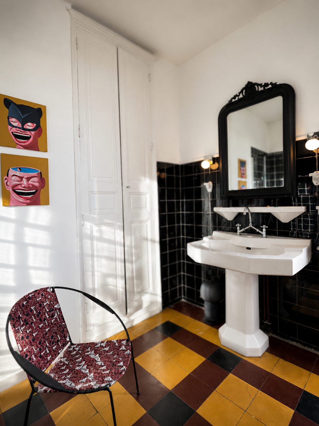 Le lavabo ancien et les tableaux pop art de la salle de bain