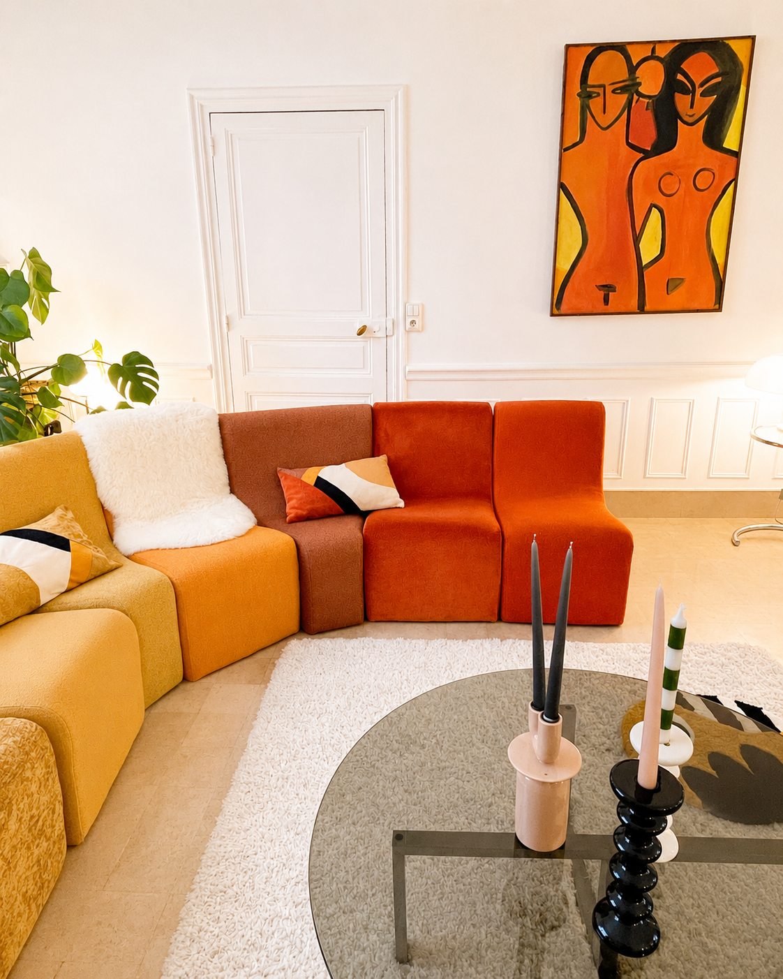 Le canapé modulable ocre du salon de la Villa Folie, sous une grande œuvre colorée