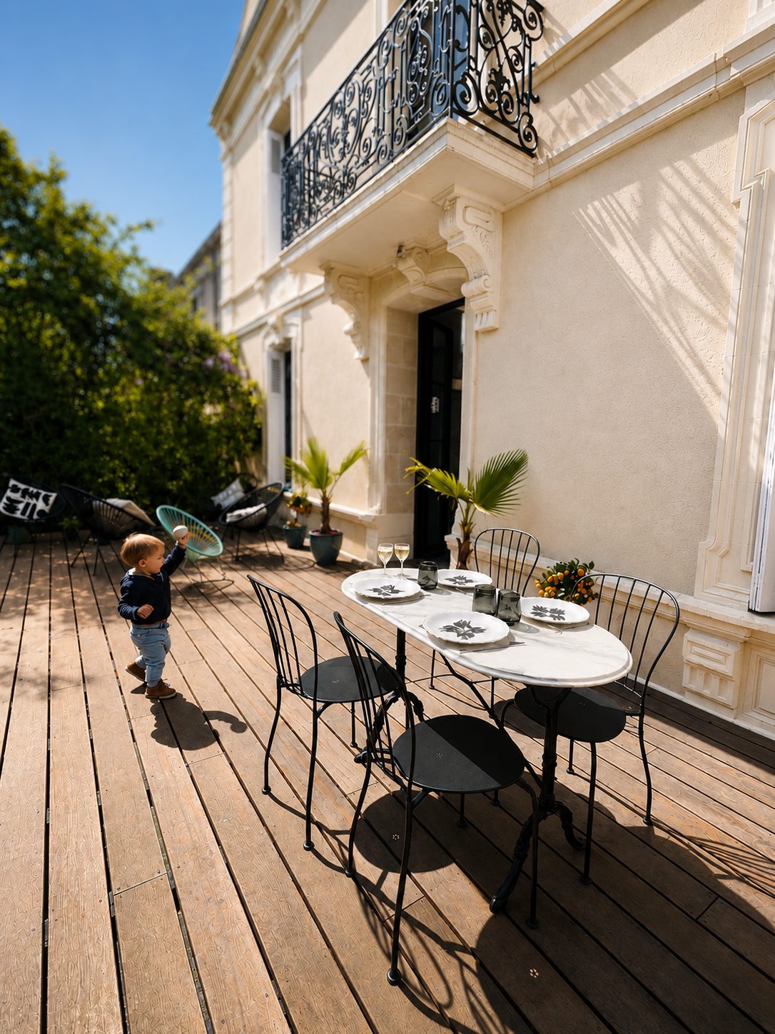 Petit-déjeuner servi sur la table de bistrot de la terrasse de la Villa Folie, au soleil du matin